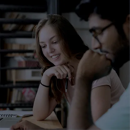Deux étudiants en comptabilité qui étudient et sourient 