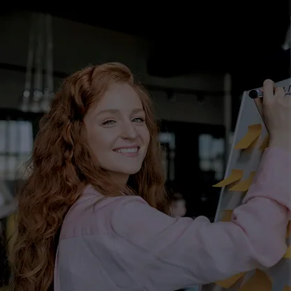 Etudiante en Communication qui travaille sur un tableau avec des post-it