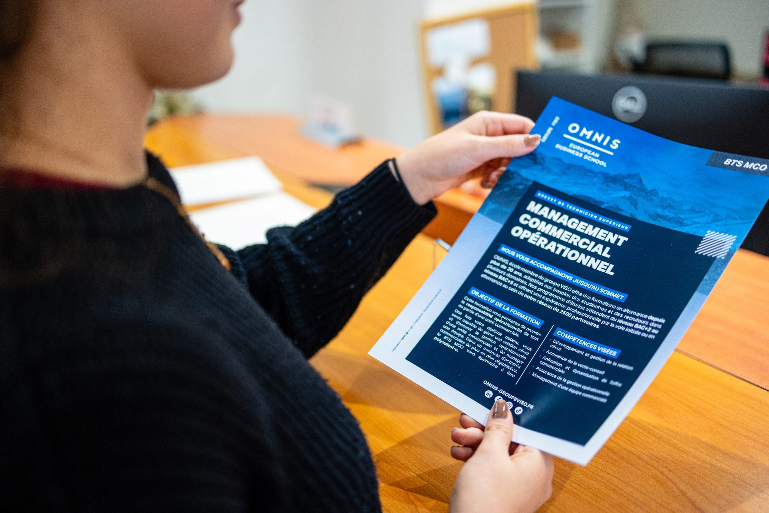 Étudiante avec une plaquette de formation dans les mains