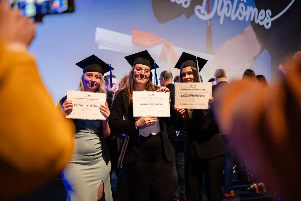 Étudiantes tenant leur diplôme pour une photo lors de la cérémonie de remise des diplômes