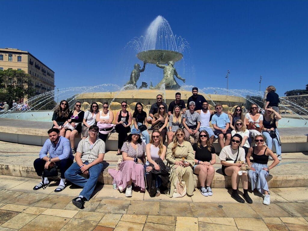 Photo de groupe des étudiants devant une fontaine