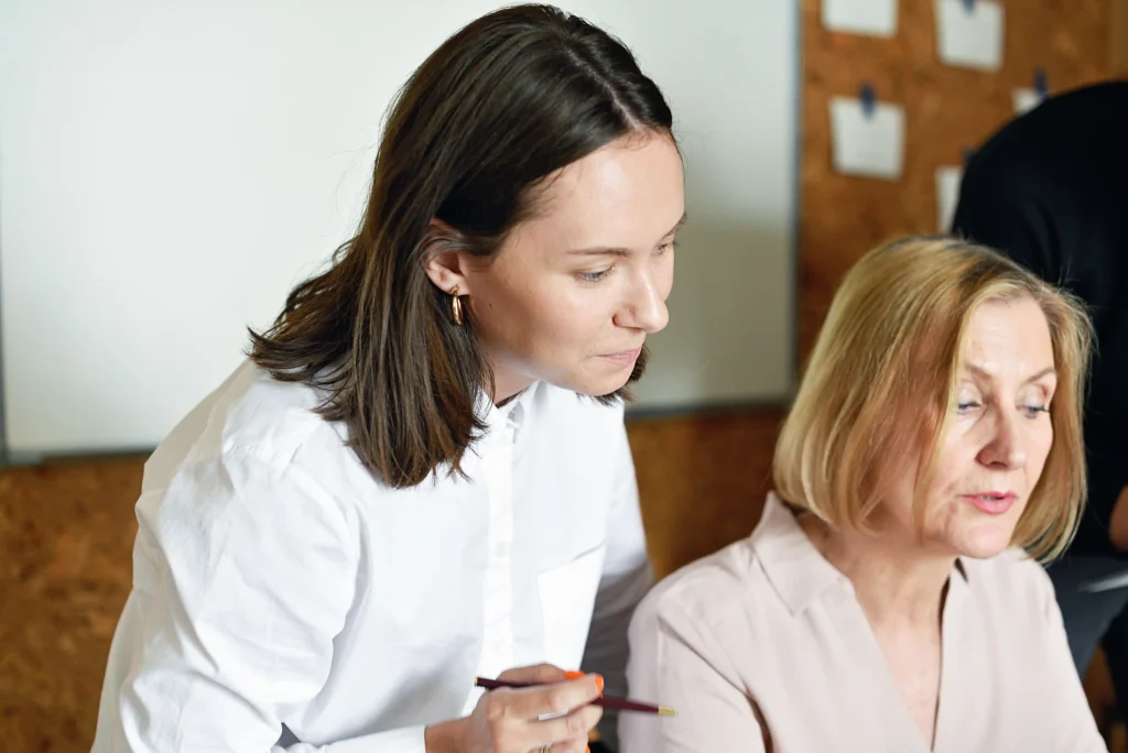 Responsable formation et son assistante discutant de leur travail de manière collaborative dans un bureau moderne