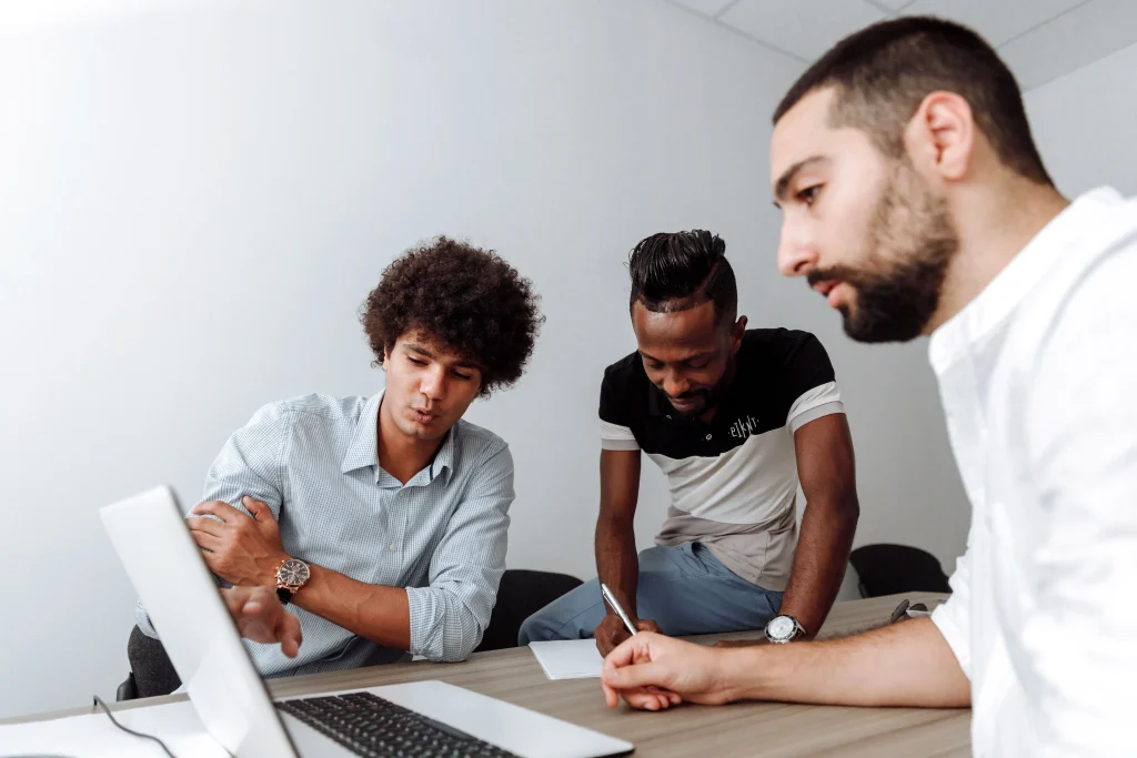 Responsable formation collaborant avec l'équipe commerciale dans une salle de réunion de bureau avec un ordinateur portable